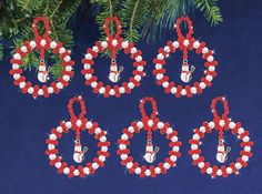 six red, white and blue christmas ornaments hanging from a pine tree on a blue background