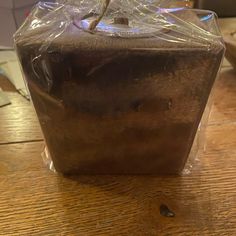 a wooden table with a plastic bag on top of it and a plant in the middle