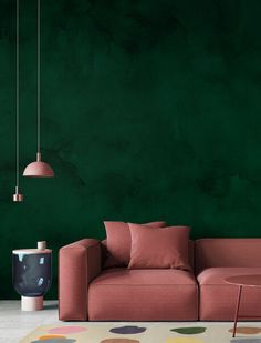 a living room with green walls and pink furniture in the corner, including a sofa