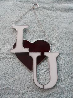 the letter i is in the shape of a heart and hangs on a silver chain