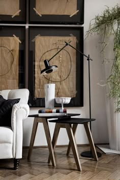 a living room filled with furniture and paintings on the wall above it's coffee table