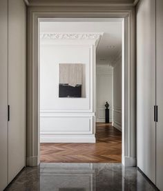 an empty room with white walls and wood floors