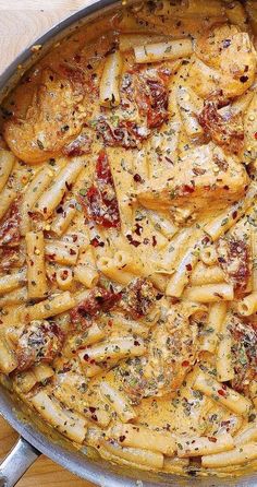 a pan filled with pasta and sauce on top of a wooden table