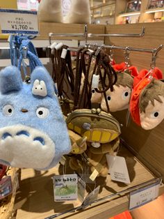 several stuffed animals hanging from hooks in a display case at a toy store with price tags on them