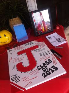 a red table topped with a white board covered in writing next to a yellow smiley face