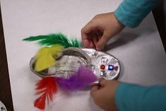 a child is making a tin can with feathers