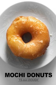 a doughnut on a white plate with the words mochi donuts above it