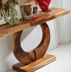 a wooden table with some vases and books on it's shelf next to a painting