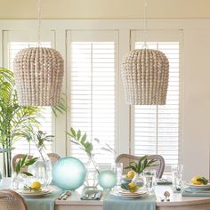 a dining room table set with plates and place settings