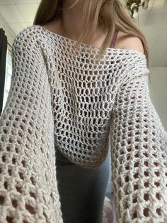 a woman wearing a white crocheted sweater