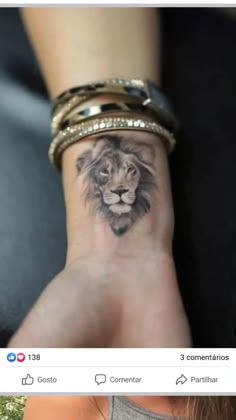 a woman's wrist with a lion tattoo on it