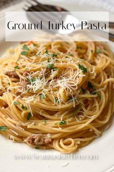 a white plate topped with pasta covered in sauce and parmesan cheese next to a fork