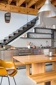 a kitchen with an island and stairs in the background