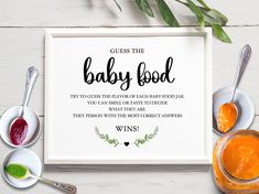 a baby food sign next to bowls and spoons on a white wooden table with greenery