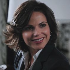 a woman in a business suit smiling at the camera