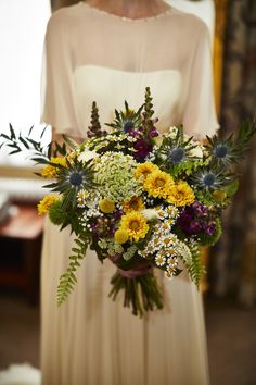 a woman holding a bouquet of flowers in her hands