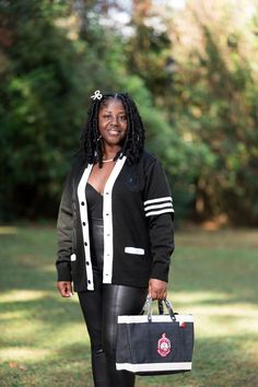 a woman in black and white holding a bag