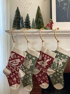 christmas stockings hanging from a mantel in front of a fireplace