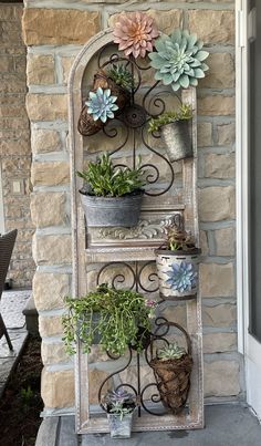 an old window is filled with potted plants and hanging from it's sides