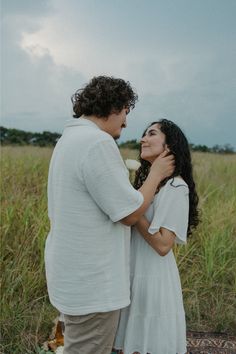 a man standing next to a woman in a field