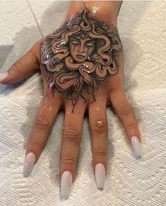 a woman's hand with an intricate tattoo on it