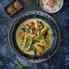 a blue plate topped with green curry and vegetables