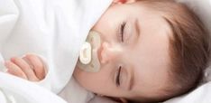 a baby is sleeping with a pacifier in its mouth and it's eyes closed