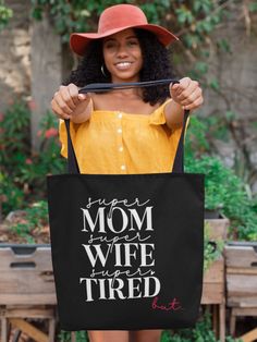 Showcase the beauty of motherhood with our uniquely designed 'Personalized Tote Bag for Mama', featuring distinct graphics on each side, perfect for the multifaceted modern mom. The front reveals an endearing message in elegant script: 'Super Mom, Super Wife, Super Tired', perfectly capturing the daily life of a dedicated mother, but adding a touch of humor and reality that every mom can relate to, acknowledging the everyday hustle with a wink and a smile. Flip it over, and the back is adorned with a playful and colorful 'MAMA' motif, embellished with floral designs, mushrooms, and hearts, celebrating the joy and vibrancy of mom life, complete with customizable names for a truly unique accessory. This tote bag combines functionality with style, making it an ideal companion for daily errand Personalized Bags For Mother's Day, Mother's Day Bags With Letter Print, Mother's Day Gift Shoulder Bag With Letter Print, Black Everyday Shoulder Bag For Mother's Day, Black Rectangular Shoulder Bag For Mother's Day, Black Shoulder Bag For Everyday, Black Gift Bag For Mother's Day, Black Large Capacity Bag For Mother's Day, Mother's Day Black Gift Bag