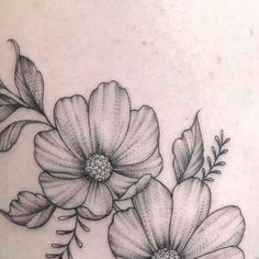 a black and white photo of flowers on the back of a woman's shoulder