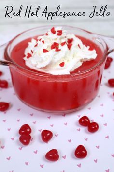 red hot apple jello with whipped cream and cherries in a glass dish on a table