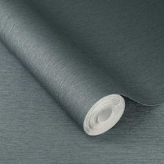 a roll of metallic fabric on a grey background