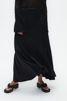 Glide through your day in the light and airy style of Nocturne. This long skirt features an elastic waistband for an effortless silhouette. Dry Clean Material: 76% Rayon 22% Viscose 2% Elastane High rise Officially licensed Imported Brand: Nocturne Model Product Size: S Model Size: Height 5'10 / Bust 29.5 in / Waist 23 in / Hips 34 in True the size Chic Flowy Rayon Maxi Skirt, Flowy Long Viscose Skirt, Viscose Flowy Maxi Skirt With Lining, Flowy Viscose Maxi Skirt For Spring, Chic Flowy Draped Skirt For Spring, Chic Asymmetrical Draped Skirt, Spring Rayon Maxi Skirt, Pleated Flowy Skirt With Asymmetrical Hem, Fall Flowy Long Wrap Skirt