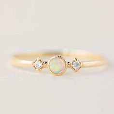 "Three stone opal and diamond ring is called \"Star and Moon Ring\", made in 100% recycled solid 14k gold. This unique ring is inspired by vintage art deco style ring, it is very lightweight and comfortable on your finger. Opal is known as the gem of brilliance and mystery. It is the birthstone for the month of October so it will make a unique birthday gift for October babies. This dainty ring has a 3mm natural white opal, with accented with ethically sourced G SI white diamonds. Opal is a soft Dainty Ethiopian Opal Promise Ring, Opal Three-stone Ring For Anniversary, Anniversary Three Stone Opal Ring, Dainty Ethiopian Opal Ring, Starburst Diamond Ring, Moon Star Ring, Moon And Star Ring, White Opal Ring, Star And Moon