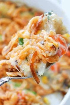 a close up of a spoon full of pasta casserole with meat and vegetables