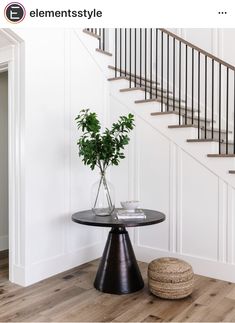 a table with a plant on it next to a stair case