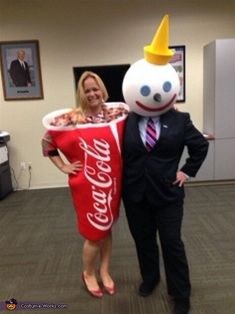 a man and woman dressed in costumes standing next to each other with a large candy cornucre