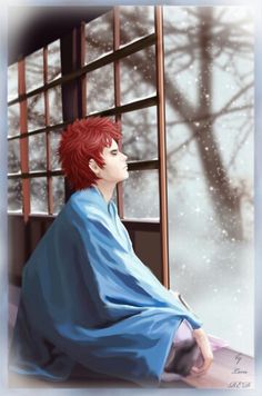 a man with red hair sitting in front of a window