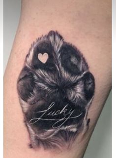 a black and white photo of a dog's paw with the word lucky on it