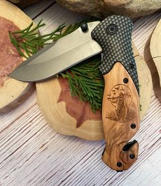 a knife is laying on top of some wood slices and pine needles in the foreground