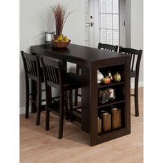 a kitchen table with four chairs and a shelf filled with fruits and vegetables on it