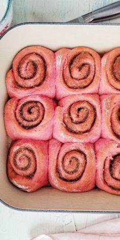 a pan filled with cinnamon rolls on top of a table