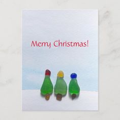 three glass bottles sitting next to each other on top of a white card that says merry christmas