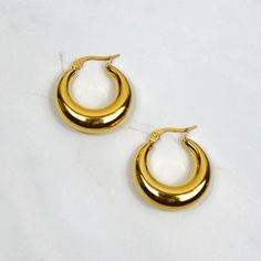 Go big, bold and gold with these medium chubby hoops - your new go-to earrings. Their classic sculptural shape give an absolutely gorgeous statement. Wear on their own or with simpler styles, for that curated look.  Featuring a latch back closure. Materials 18k Gold plated stainless steel. Hypoallergenic. Shipping Free UK shipping 48-hour Tracked Delivery, with option to upgrade to 24-hour Tracked Delivery at checkout.  Packaging & gifting All of our earrings come in a luxury velvet pouch. If yo Gold Chunky Round Earrings, Earrings Classic, Bold Earrings, Velvet Pouch, Everyday Earrings, Gold Hoops, Jewelry Earrings Hoops, Hand Decorated, Medium Size