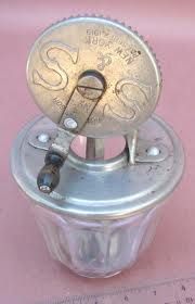 a close up of a metal object on a pink table top with measuring tape in the background