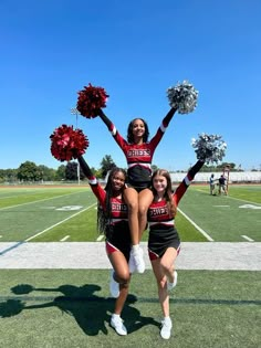 two cheerleaders are doing stunts on the field