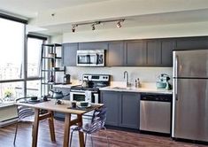 an apartment kitchen with stainless steel appliances and wood flooring is pictured in this image