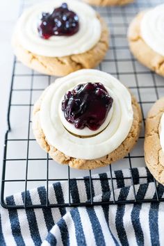 cookies with cream and blueberry toppings on a cooling rack