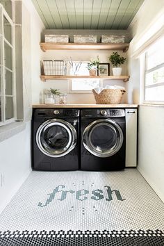 a washer and dryer in a small room with open shelving on the wall