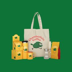 a tote bag with coffee and other items in front of it on a green background