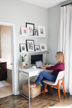 a woman sitting at a desk in front of a computer on top of a white table